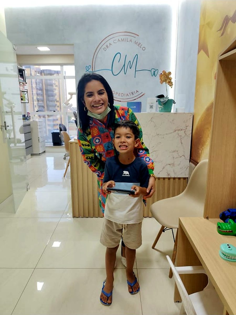 Dra. Camila Melo ao lado de paciente na recepção da clínica
