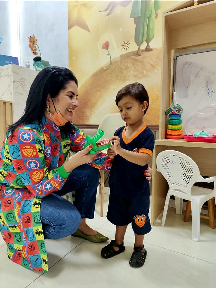 Dra. Camila Melo ensinando escovação a um paciente no espaço lúdico