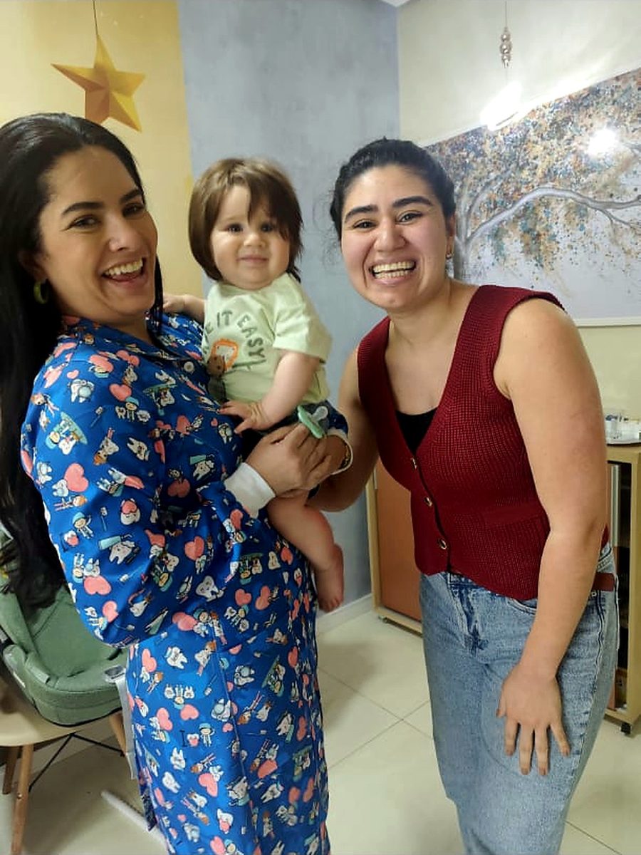 Dra. Camila Melo com bebê e a mãe após o atendimento