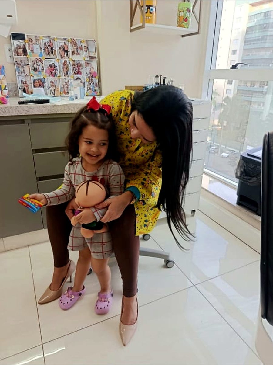 Dra. Camila Melo brincando com paciente na clínica
