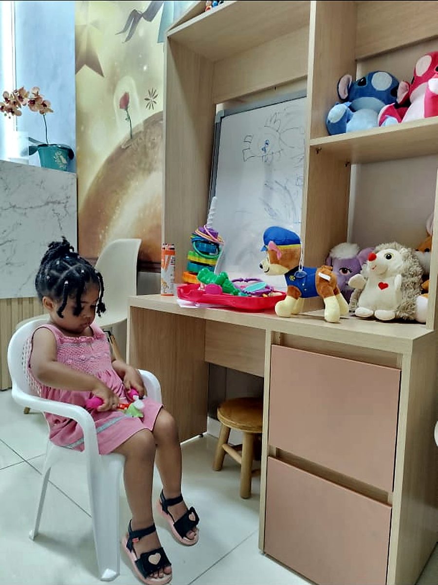 Criança brincando na mesinha do espaço infantil